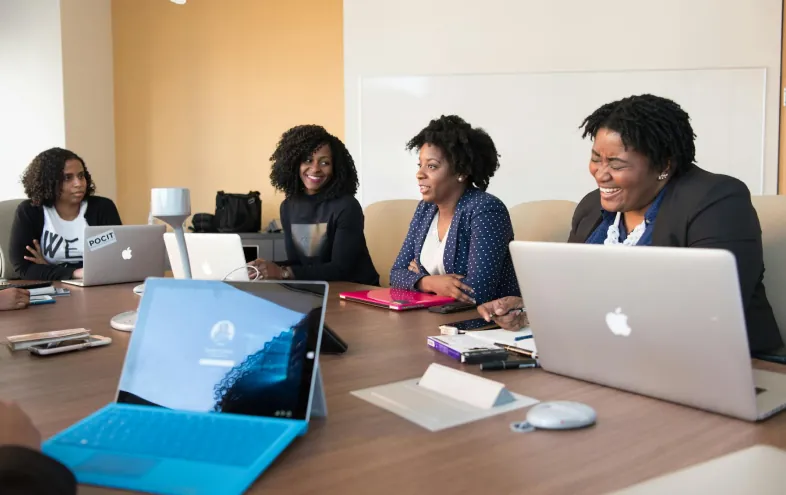 Women collaborating around laptops during a working session